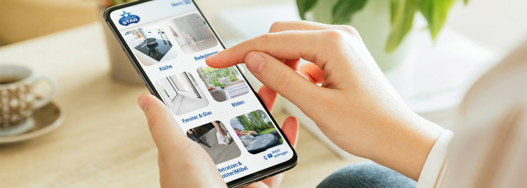 In der Hand wird ein Smarthpone gehalten, welches einen Ausschnitt der Thermostar Website zeigt
