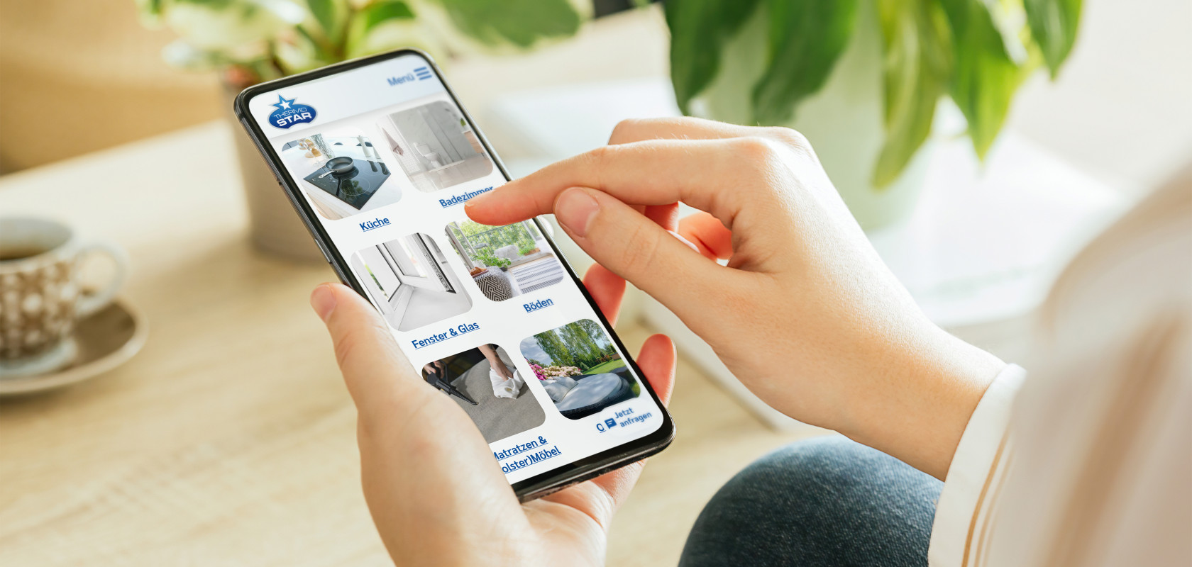 In der Hand wird ein Smarthpone gehalten, welches einen Ausschnitt der Thermostar Website zeigt