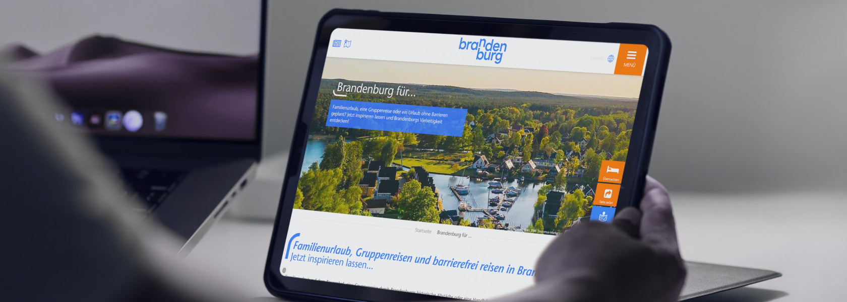 Ein Tablet das in der Hand gehalten wird und einen Ausschnitt der Brandenburg Tourismus Website zeigt.