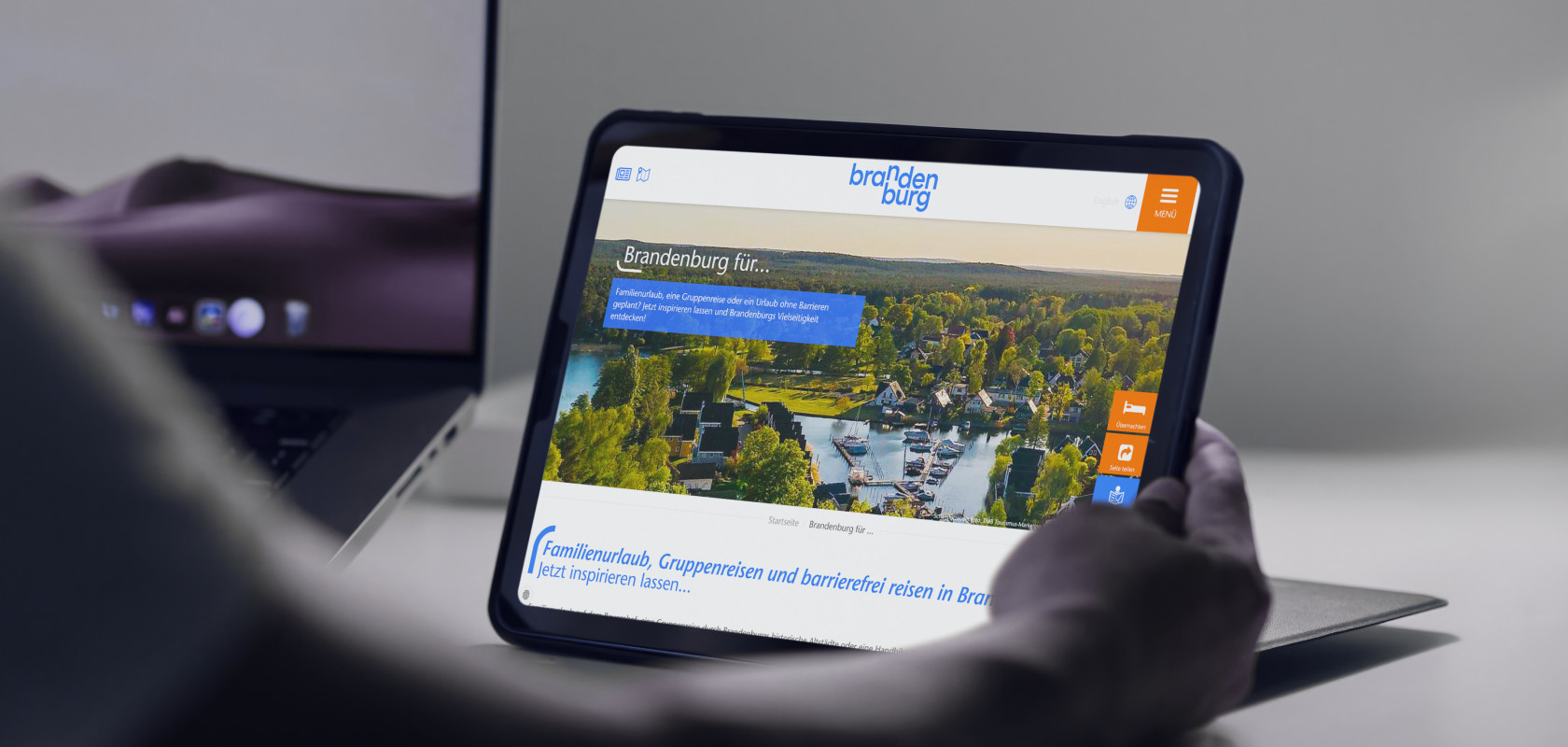 Ein Tablet das in der Hand gehalten wird und einen Ausschnitt der Brandenburg Tourismus Website zeigt.
