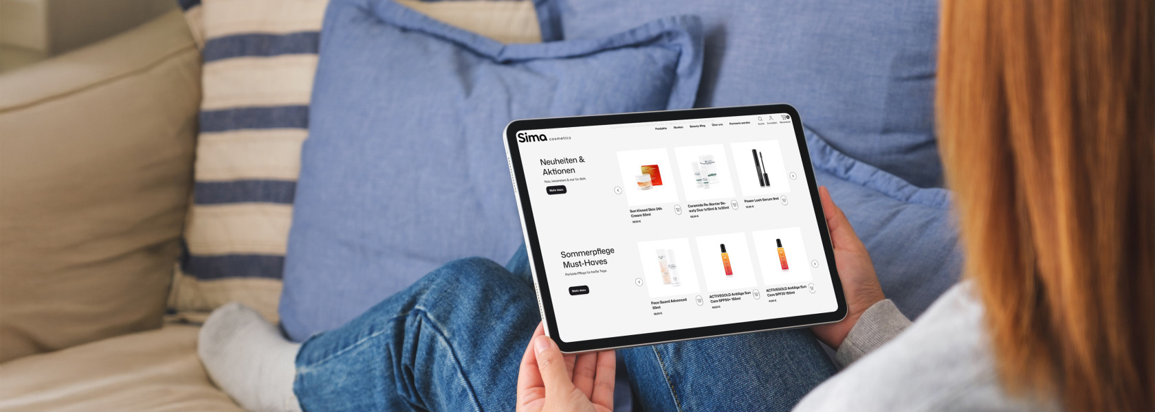 Frau auf dem Sofa die ein Tablet in ihren Händen hält das einen Ausschnitt der Sima Cosmetics Website zeigt