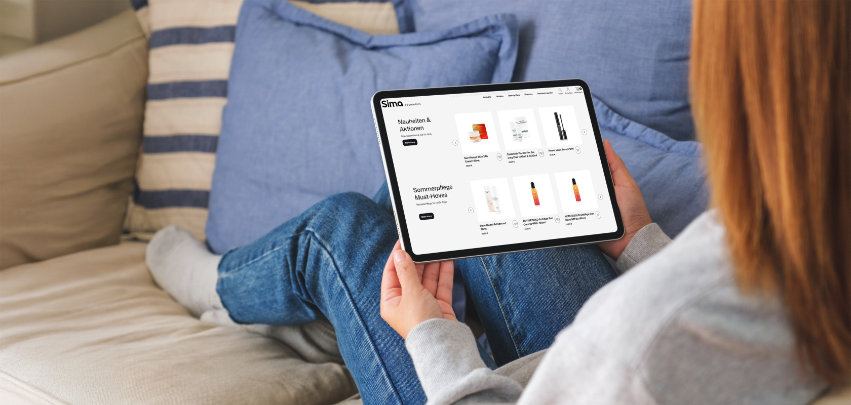 Frau auf dem Sofa die ein Tablet in ihren Händen hält das einen Ausschnitt der Sima Cosmetics Website zeigt